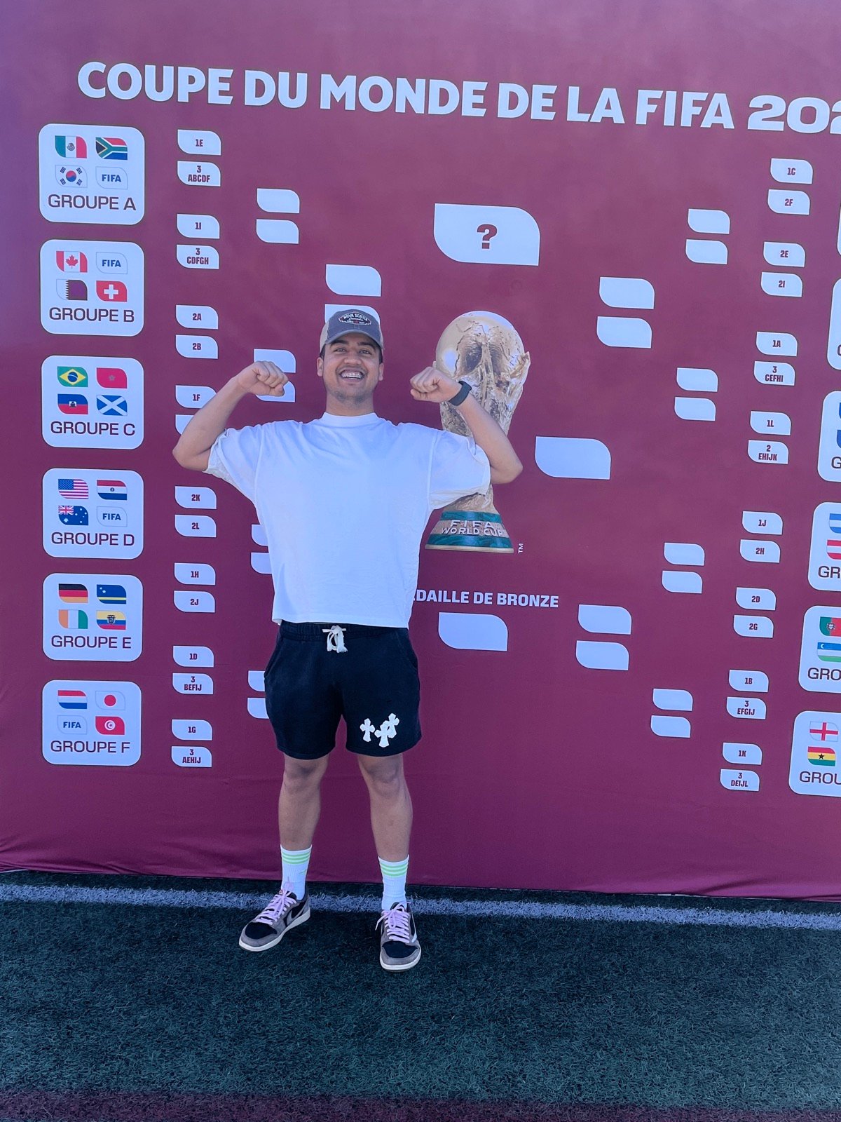 Celebrating in front of the FIFA World Cup trophy and the tournament bracket wall