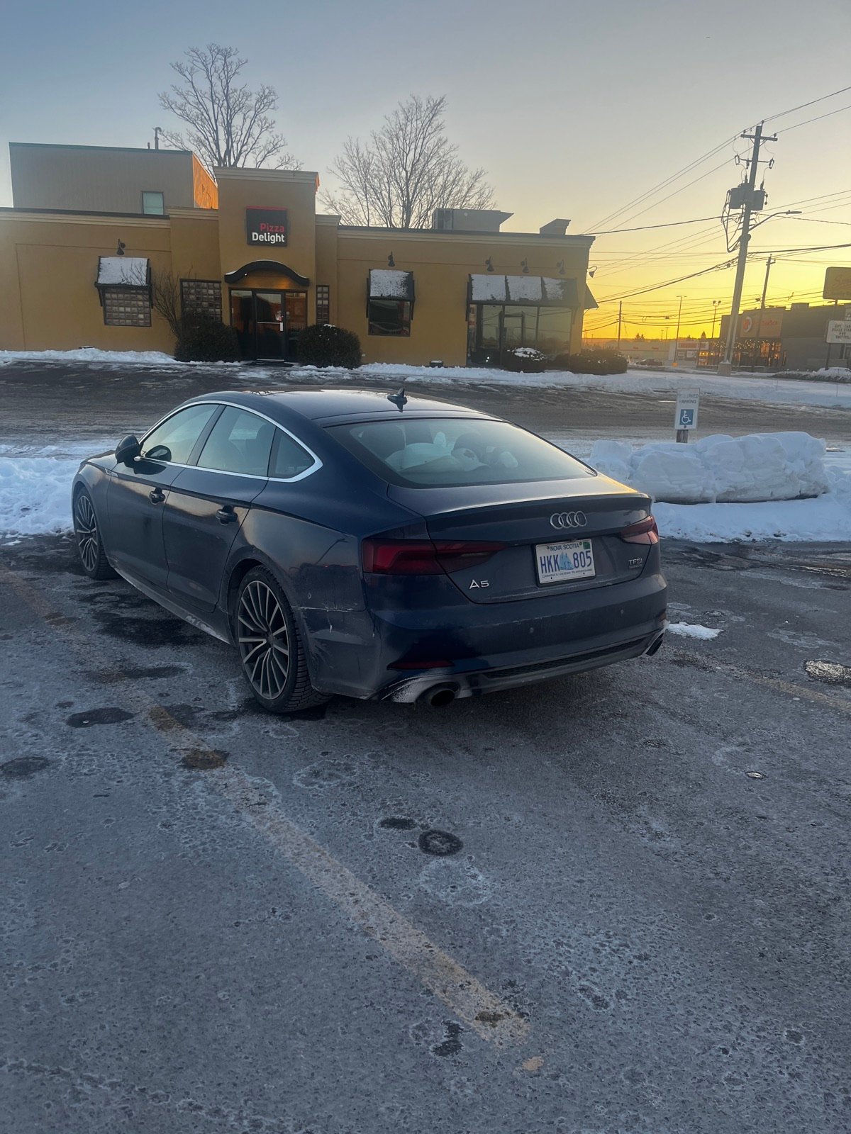 Audi A5 with a Nova Scotia plate in a snowy parking lot at golden hour